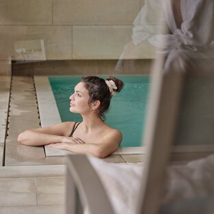 Woman relaxes in indoor pool | © Mathias Lixl