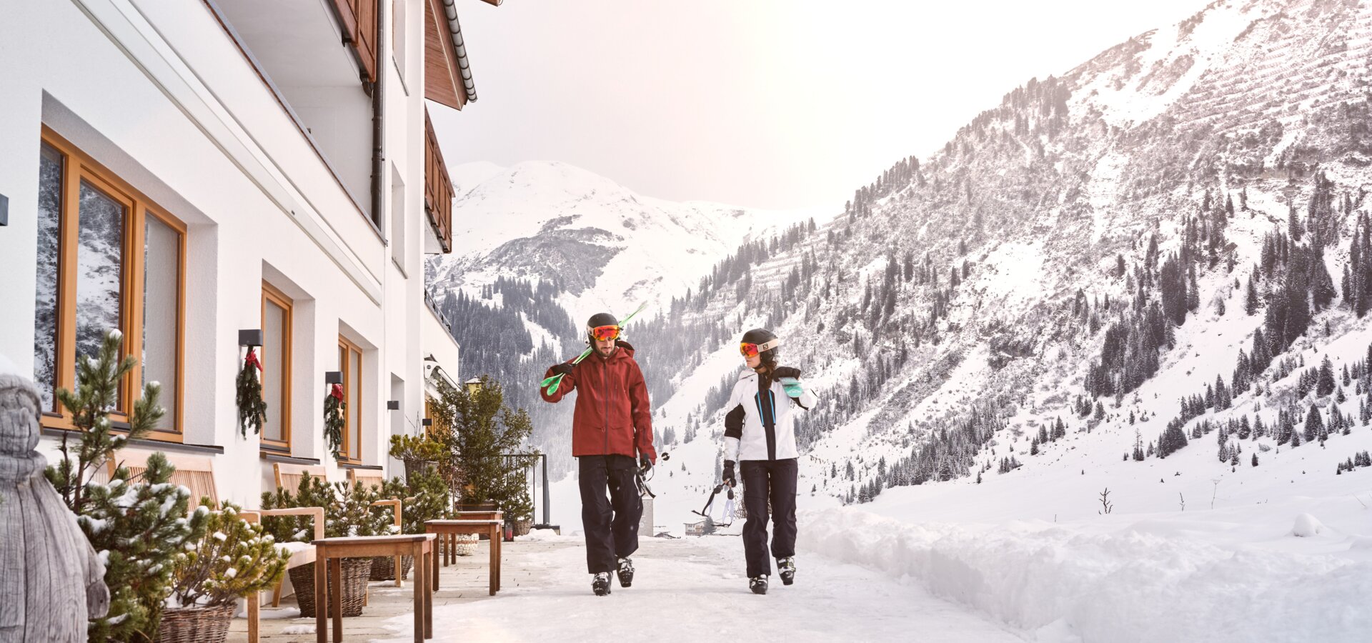 Skiers walk in front of hotel Schranz | © Mathias Lixl
